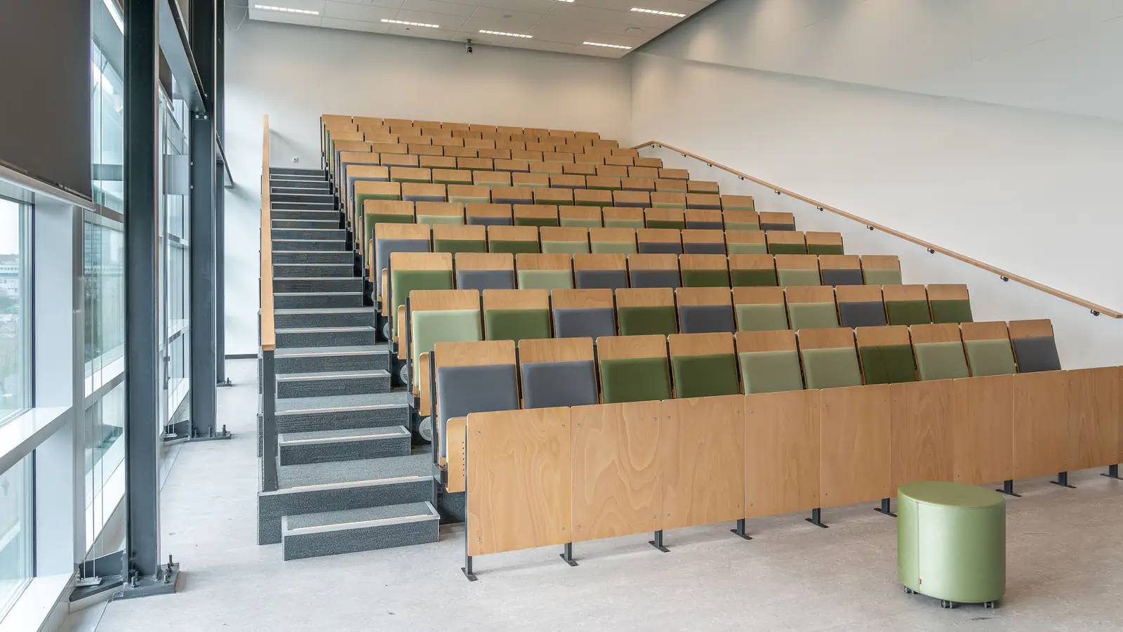 Empty, bright lecture hall with tiered wooden seating