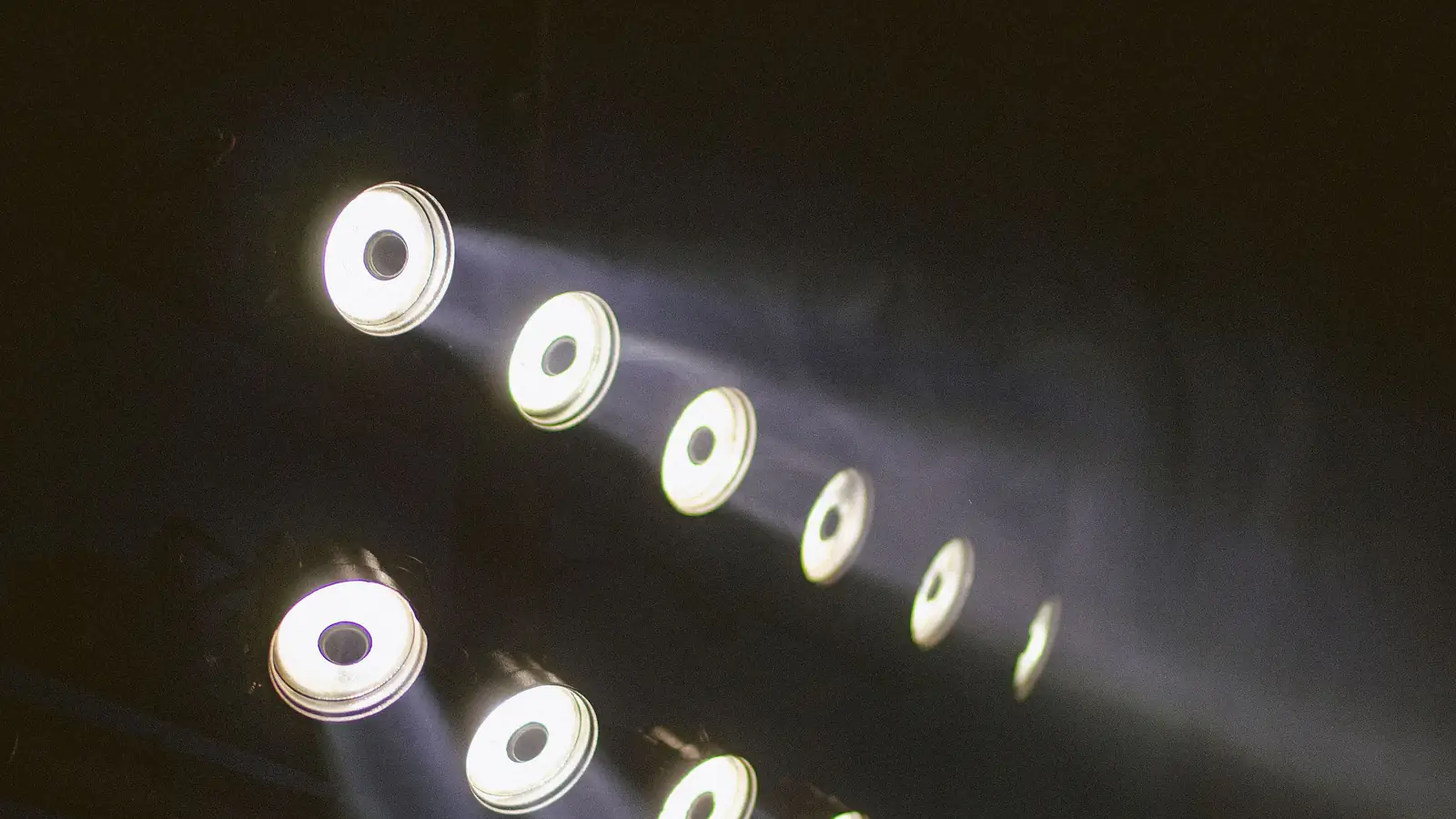 Reihen runder Scheinwerfer, die im Dunkeln Lichtkegel werfen