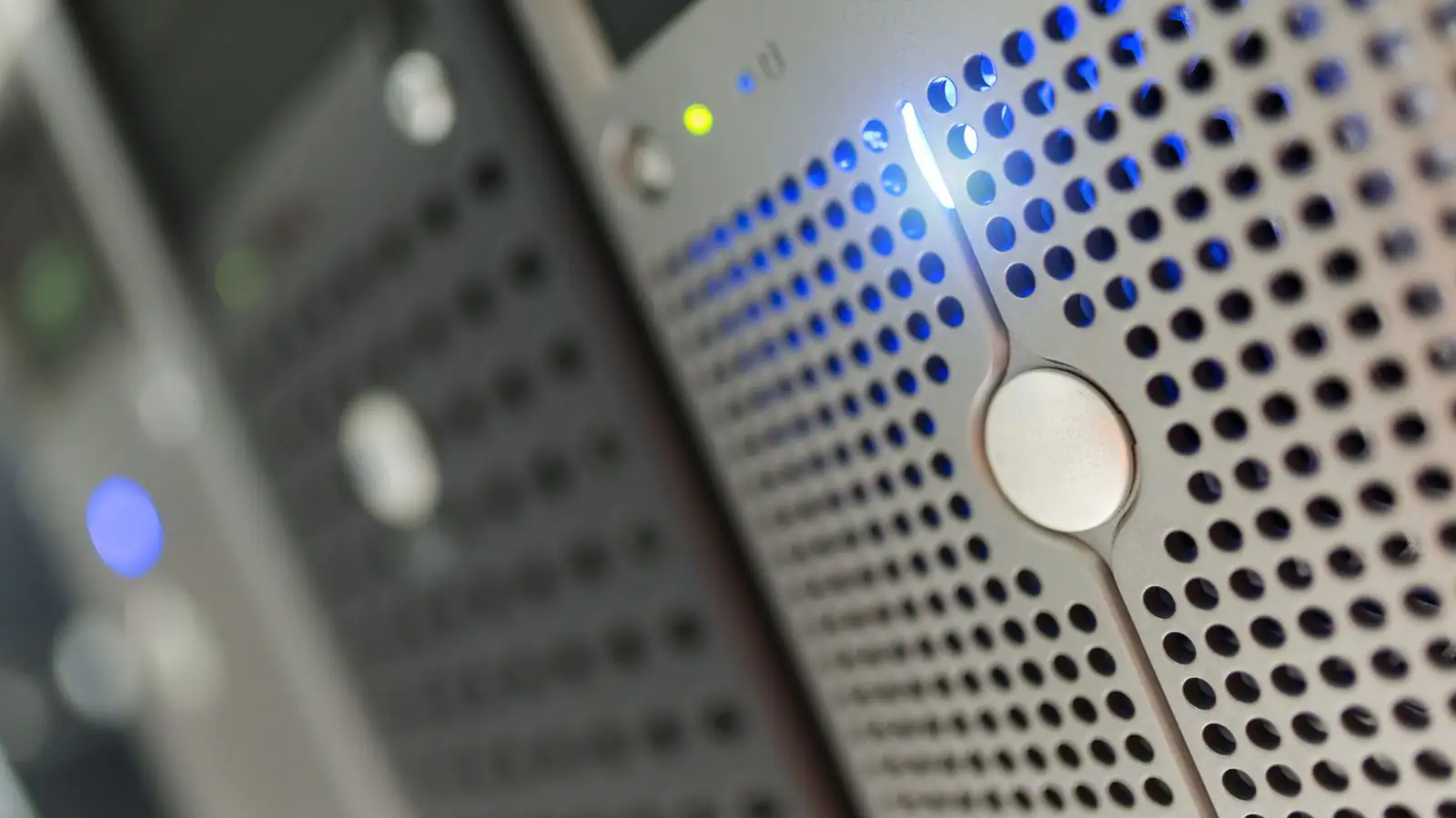 Front of a server with a perforated metal bezel and blue status lights